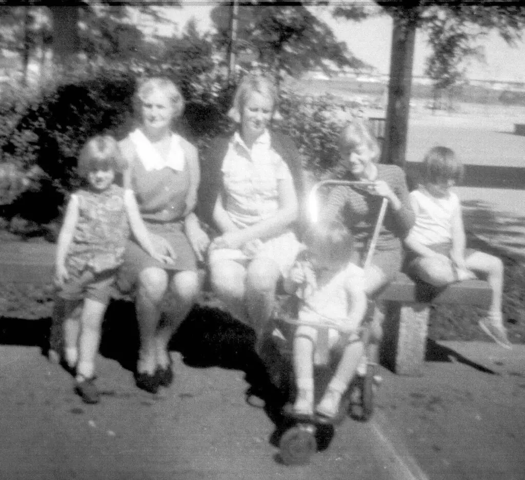 People on a bench, black and white photo.